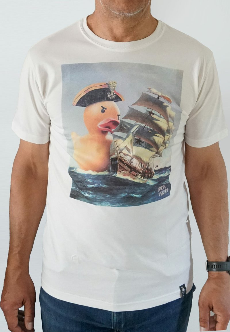 White cotton t-shirt featuring a graphic of a rubber duck in a captain's hat, juxtaposed with a sailing ship on turbulent water.