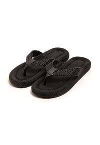 Chanclas negras de goma texturizada con un diseño trenzado en las correas, con una suela flexible y un perfil minimalista.