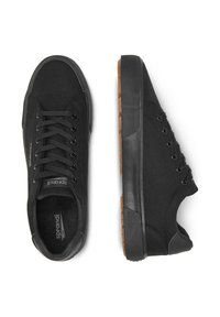 Zapatillas bajas negras con suelas de goma texturizada y partes superiores de tela, con cordones negros y el nombre de la marca "sprandi" en la lengüeta y el lateral.