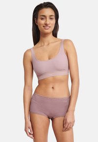 Lys lilla sømløs bh med brede stropper kombineret med matchende hipster-shorts med delikat kant og logodetalje. Blødt, elastisk stof.