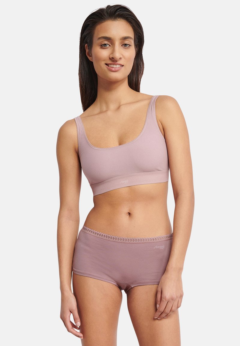 Lys lilla sømløs bh med brede stropper kombineret med matchende hipster-shorts med delikat kant og logodetalje. Blødt, elastisk stof.