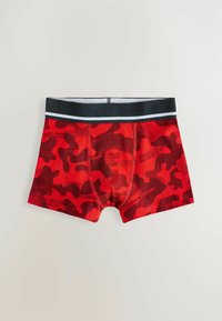 Shorts de bain camouflage rouge avec une ceinture élastique noire et des accents blancs. Tissu texturé avec des motifs et des imprimés variés.