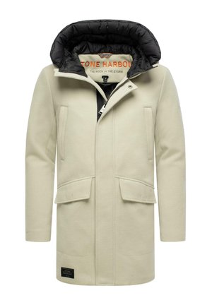 Cappotto beige chiaro con cappuccio imbottito nero removibile, due tasche frontali e un'etichetta con il marchio vicino all'orlo. Texture liscia con un design strutturato.