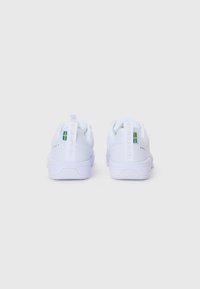 Hvide sneakers med en tekstureret mesh-overdel og gummisåler. Funktioner en blå og gul flagdetalje samt branding på hæltappen.