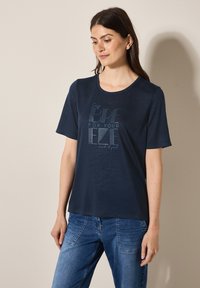 Camiseta azul marino de manga corta, con cuello redondo y diseño gráfico en el texto. Fabricada en un tejido suave con una textura lisa.