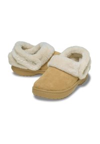 Zapatillas de ante color tostado con un suave cuello de terciopelo crema. Forma redondeada, suela texturizada y botones en el cuello para un ajuste ajustable.