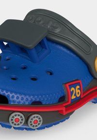 Μπλε και μαύρο παιδικό παπούτσι κλογκ με οπές αερισμού, κόκκινη επένδυση, τον αριθμό 26, και μαύρη ρυθμιζόμενη λουρίδα επάνω.