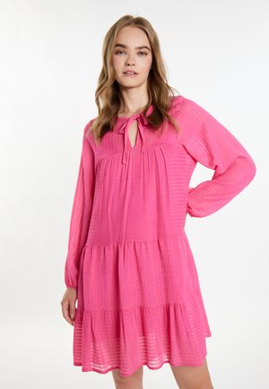 Rochie roz, cu volane, mâneci lungi și decolteu în formă de cheie. Fabricată dintr-un material texturat cu un model subtil de dungi.