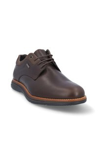 Zapato de vestir de cuero marrón con un acabado suave, punta redonda, diseño de cordones, suela de goma y costuras en contraste en tan a lo largo de la suela.