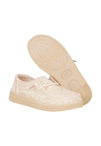 Scarpe beige chiaro con un motivo a foglia testurizzato, dotate di una tomaia in tessuto morbido, punta arrotondata e suola in gomma con dettagli intrecciati.