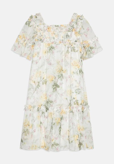 Gėlių suknelė balta su geltonais ir žaliais raštais, trumpomis pūstomis rankovėmis, kvadratine iškirpte, raukšlėtu liemeniu ir volangais apatinėje dalyje.