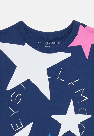Mörkblå bomull T-shirt med stora vita och rosa stjärnmönster. Rund hals med prickig textdesign runt stjärnorna.