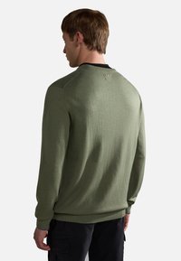 Olivgrüner Sweatshirt mit strukturiertem Finish, gerippten Bündchen und Saum, ausgestattet mit einem schwarzen Ausschnitt und einem kleinen Logo-Detail auf der Rückseite.