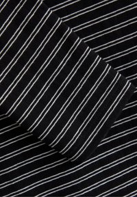 Tessuto nero con sottili strisce orizzontali bianche. La texture è a coste e i bordi sono rifiniti con un orlo pulito.