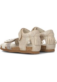 Bicolour sandaal in metallic goud en licht crème, met een open ontwerp, klittenbandsluiting en franjes aan de hiel. Kurken zool.