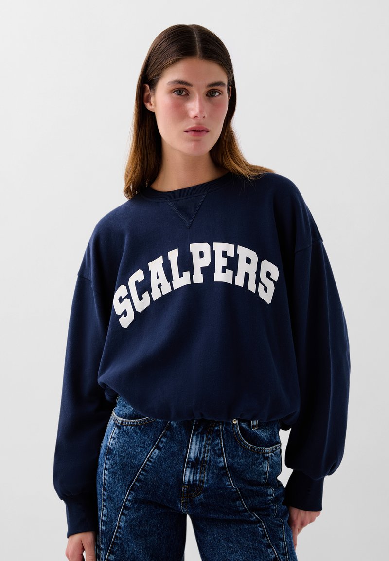 Marineblå oversized sweatshirt med "SCALPERS" i hvide fede bogstaver på brystet, med en klassisk rund halsudskæring og ribbede manchetter.