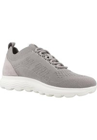 Scarpa atletica in mesh grigia con un morbido accento in suede grigio, suola imbottita bianca e parte superiore testurizzata con un motivo traspirante.