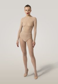 Nude fisht-net bodysuit med långa ärmar och en åtsittande design. Har ett diamantmönster över hela. Matchas med nakna högklackade skor.
