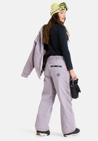 Snowboard outfit featuring a purple jacket and pants, black long-sleeve top, and yellow beanie. Gloves and snowboard boots visible.