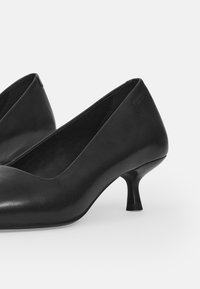 Zwarte leren hoge hakken met een spitse neus en een slanke stilettohak, met een gladde textuur en een eenvoudig ontwerp.