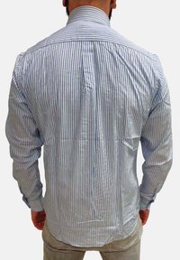 Camicia a righe blu e bianca, con colletto rigido e maniche lunghe, dotata di una vestibilità su misura evidenziata dalle pieghe posteriori e dai dettagli delle cuciture.
