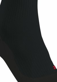 Calcetín deportivo negro con textura acanalada, punta reforzada y acento de logo rojo. Fabricado con un material ligero que absorbe la humedad.