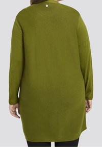 Top de punto de manga larga en verde profundo con textura de canalé vertical, dobladillo redondeado y un cierre de un botón en la parte posterior del cuello.