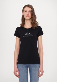Tricou negru, ajustat, din bumbac moale, cu un logo "A|X ARMANI EXCHANGE" decorat cu cristale strălucitoare pe partea din față. Mâneci scurte, gât rotund.