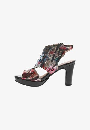 Sandale à talons hauts noire avec un motif découpé floral, des accents multicolores et une plateforme élégante. Cuir texturé et bords en forme de vagues.