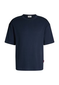 Granatowy bawełniany t-shirt z okrągłym dekoltem, krótkimi rękawami, luźnym krojem i małą czerwoną metką z logo z boku. Gładka tekstura, jednolity design.