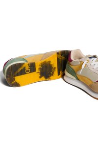 Scarpe sportive multicolori con una combinazione di materiali testurizzati: camoscio beige, pelle verde, accenti gialli e bordeaux, e una suola in gomma con motivo.