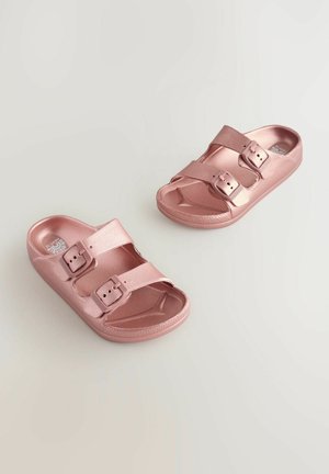 Sandales à enfiler métalliques roses avec deux sangles réglables dotées de boucles. Surface lisse avec un bout arrondi et une semelle texturée.