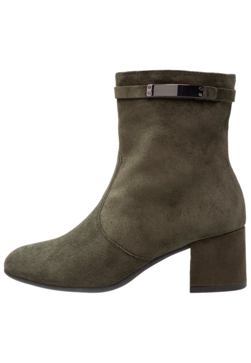 Botín de tobillo en ante verde oliva con punta cuadrada y un tacón grueso. Presenta una tira delgada con herrajes metálicos en el puño.