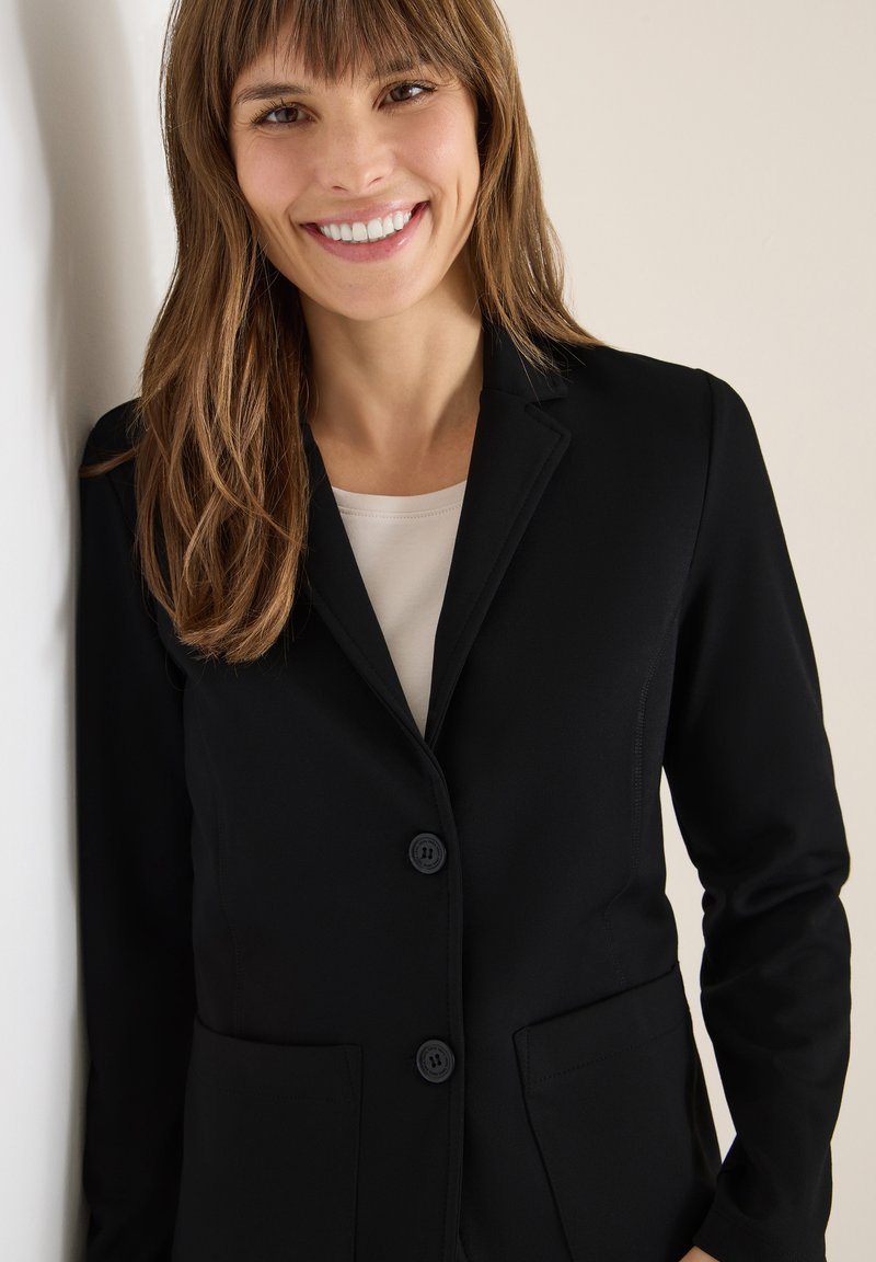 Blazer nero con due tasche frontali, design a un petto e due bottoni. Tessuto liscio con vestibilità slim e colletto a punte.