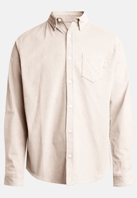 Beige kordtrøje med knapkrave, lange ærmer, brystlomme og hvide knapper. Tekstiler med lodret ribbing.