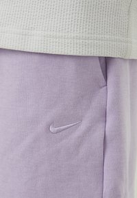 Elastische katoenmix shorts in lichtpaars, met geborduurd Nike-logo. Zachte textuur, rechte snit, zijzakken, casual ontwerp.