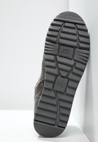 Šedá obuv s gumovou podrážkou. Obsahuje texturovaný vzor v profilu a branding "soft flex". Na podrážce jsou vyznačeny velikosti.