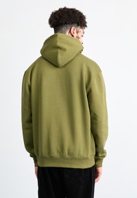 Felpa verde oliva con un ampio cappuccio, polsini e orlo a costine. Realizzata in un tessuto morbido, presenta una vestibilità comoda e una texture liscia.