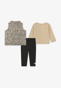 Conjunto para niños de tres piezas: camiseta sin mangas con estampado de leopardo, camisa de manga larga beige y leggins negros con acanaladuras y logo blanco.