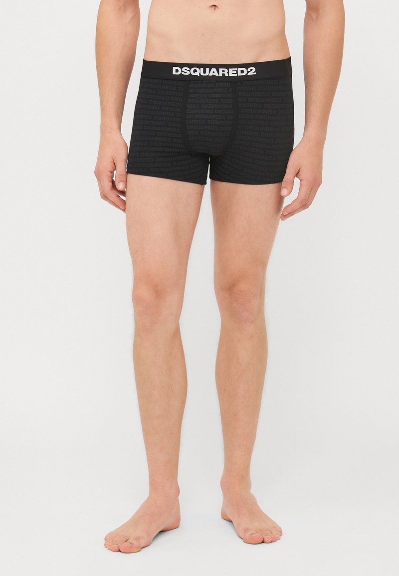 Black boxer briefs featuring a repeated logo pattern, elastic waistband with "DSQUARED2" branding, fitted design, and soft material.