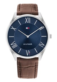 Silberfarbene Uhr mit einem strukturierten, marineblauen Zifferblatt, römischen Ziffern als Markierungen und einem braunen, krokodilmusterförmigen Lederarmband. "HILFIGER"-Logo angezeigt.