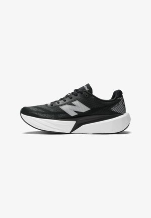 Zapatilla de correr en blanco y negro con suela gruesa, cordones y un gran logo reflectante en el lateral.