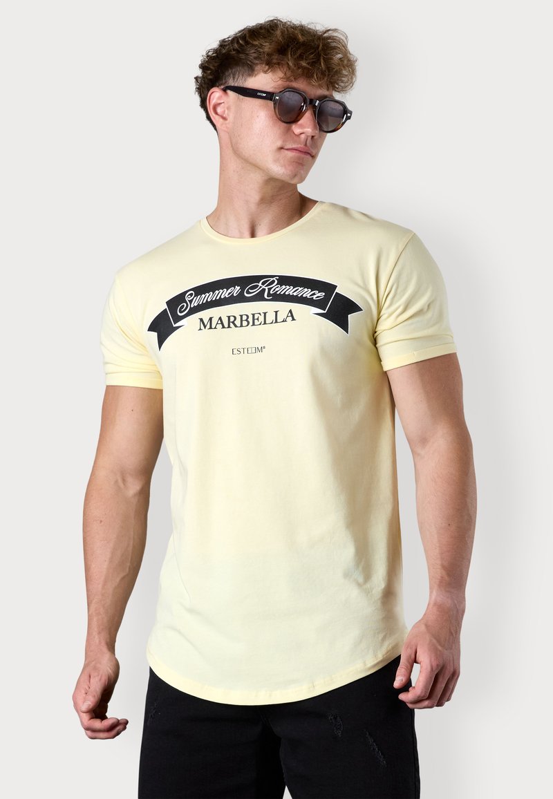 Hellgelbes Baumwoll-T-Shirt mit kurzen Ärmeln, rundem Ausschnitt und einem Grafikdruck, der "Summer Romance Marbella" in Schwarz zeigt.