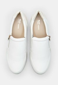 Scarpe bianche slip-on con una superficie in pelle liscia, punta arrotondata e zip laterale. L'interno presenta un'imbottitura beige.