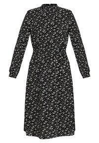 Svart klänning med långa ärmar, hög halsringning och elastisk midja. Har ett vitt prickigt mönster i hela klänningen. Slät tygstruktur.