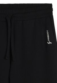Pantaloni da jogging neri in cotone con cintura regolabile e un piccolo logo argento sulla parte anteriore. Il tessuto sembra morbido con una texture liscia.