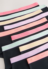 Black underwear pairs with elastic waistbands in pastel colors, each featuring the brand name "NEXT" repeated along the band.