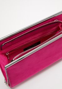 Růžové semišové psaníčko s stříbrným zipem, uvnitř kapsa a textilní podšívka. Texturovaný povrch, elegantní obdélníkový tvar.