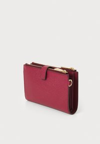 Red textured leather wallet with a zip closure, featuring gold hardware and a flap with a snap button. Compact rectangular design.