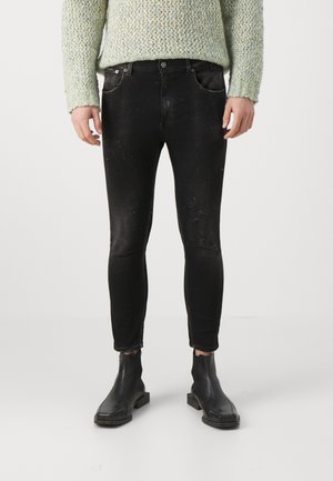 Zwarte skinny jeans met een verstoord uiterlijk, voorzien van voorzakken, een tailleband met riemlussen en een slim fit, in combinatie met zwarte enkellaarsjes.
